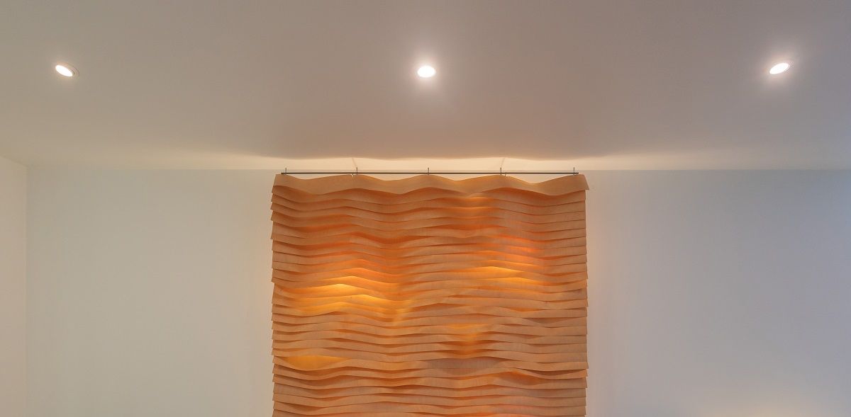 In the living room, a wall light and ceiling downlights create a functional combination.
